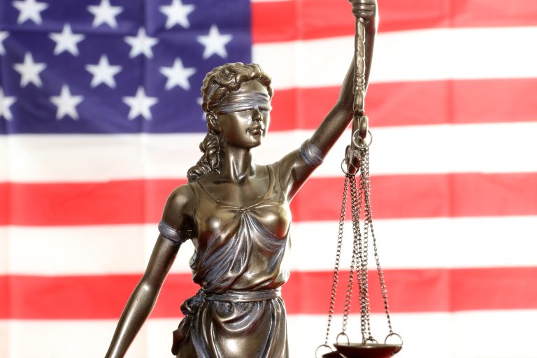 Lady Justice in front of American flag